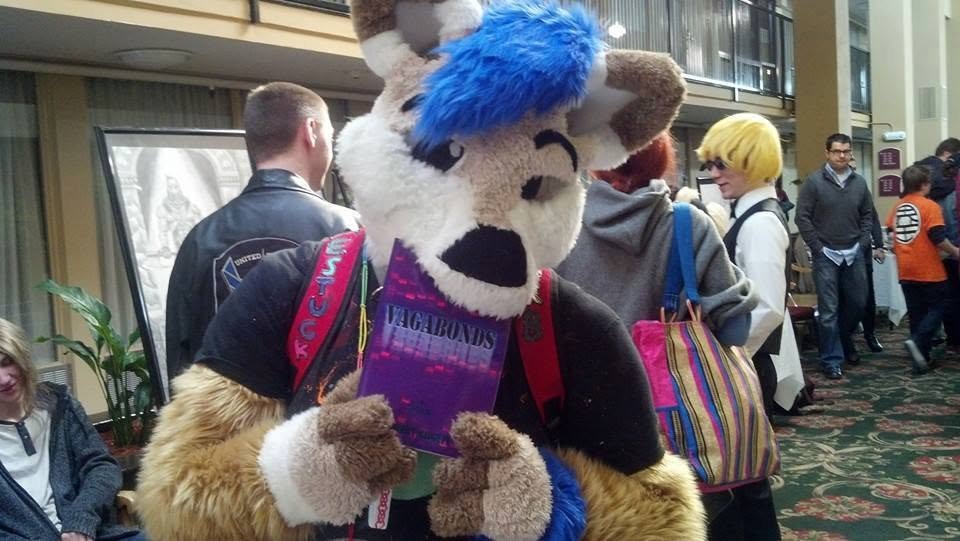 A convention-goer in a costume holding a copy of Vagabonds